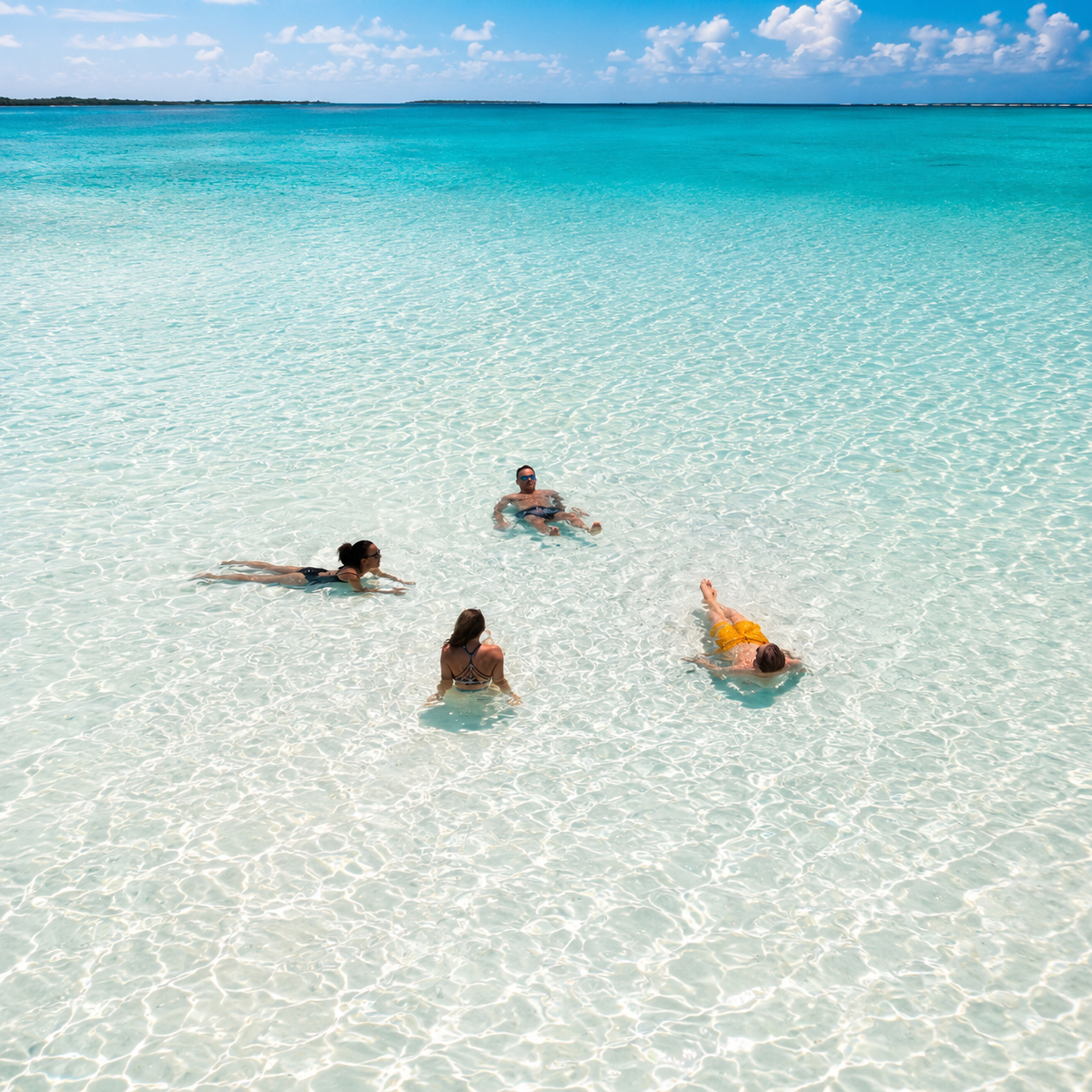 Friends swimming in glass-clear Bahamian water